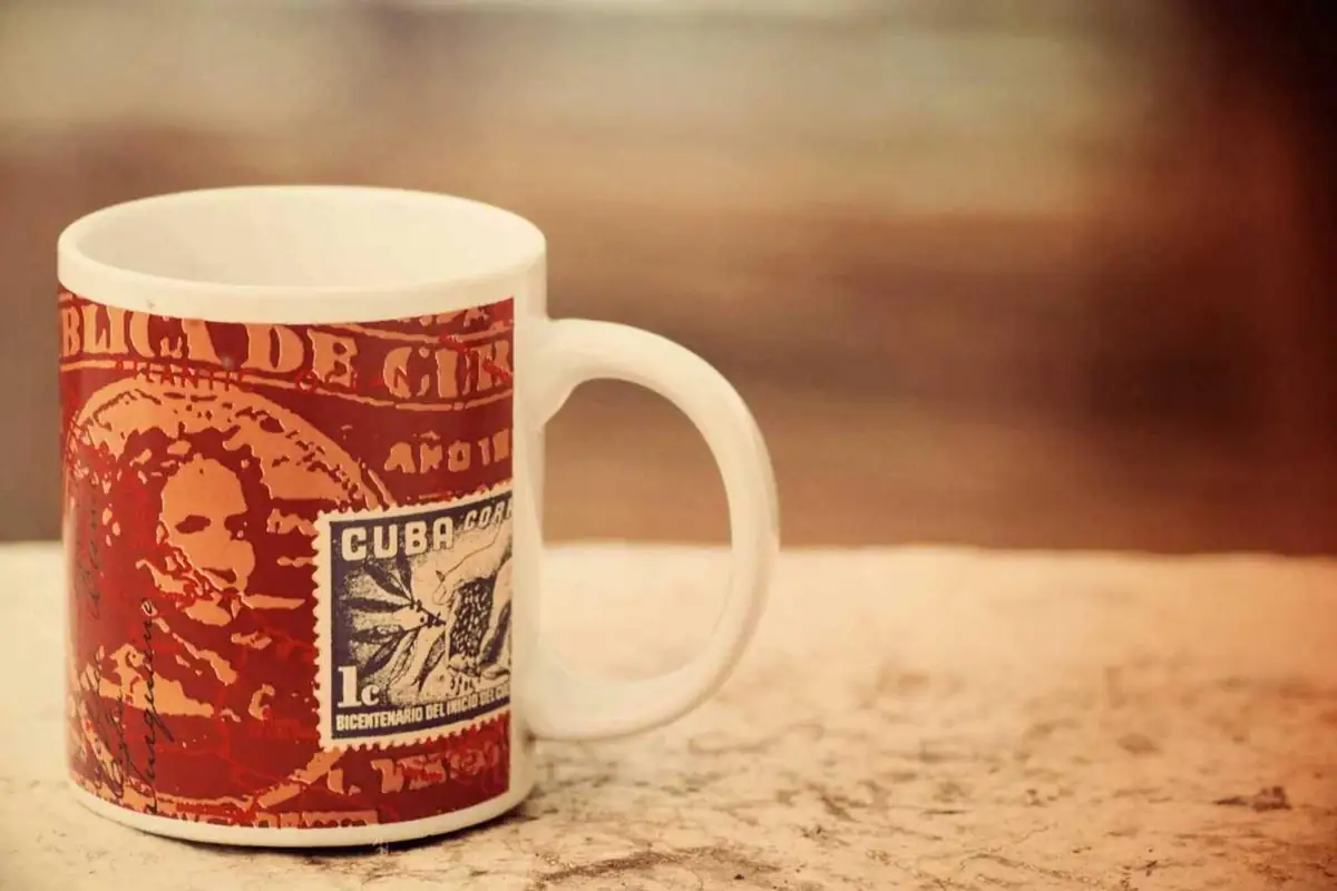 A red and white mug printed with a postage stamp