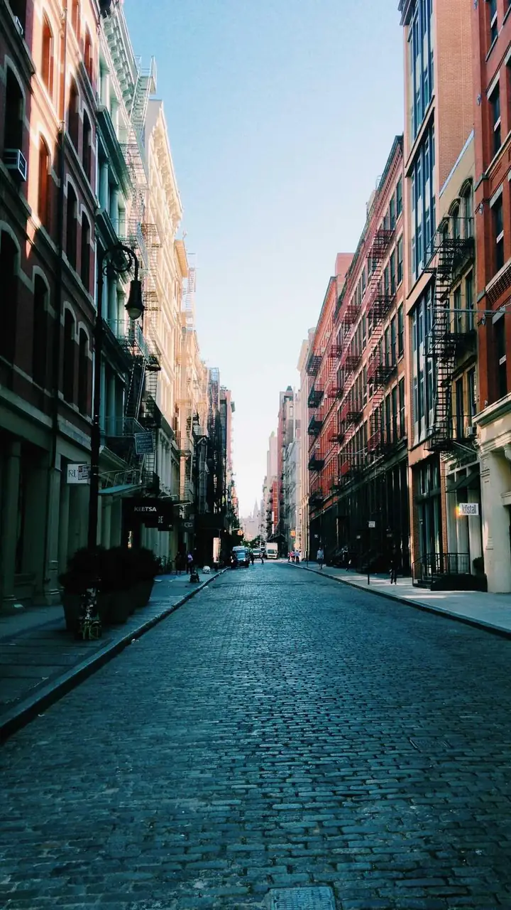 A cobbled street between brick buildings